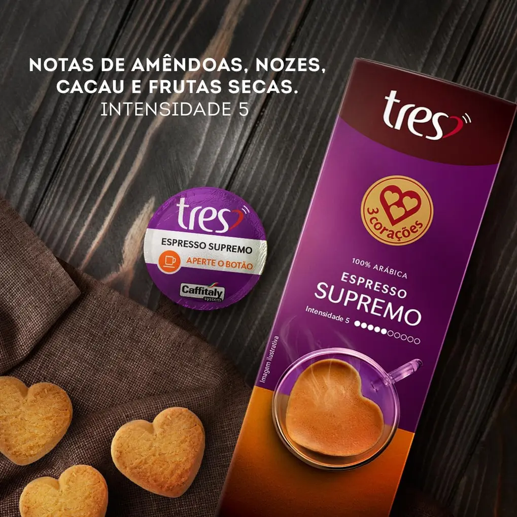 Xícara de café espresso com crema densa, e a caixa das 3 Corações Cápsulas Supremo TRES desfocada ao fundo