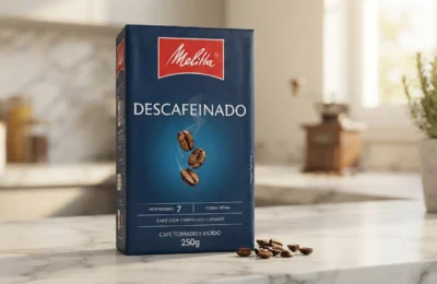 Embalagem a vácuo de 250g do Café Descafeinado Melitta sobre bancada de mármore branco em cozinha moderna.
