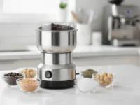 Moedor de Café Elétrico Inox na bancada da cozinha com grãos e temperos ao redor.