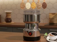 Moedor de Café Elétrico Inox em uma bancada de cozinha, com grãos e café.